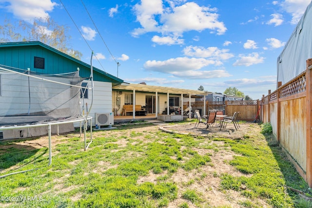 view of yard featuring a patio, a fenced backyard, a trampoline, and ac unit