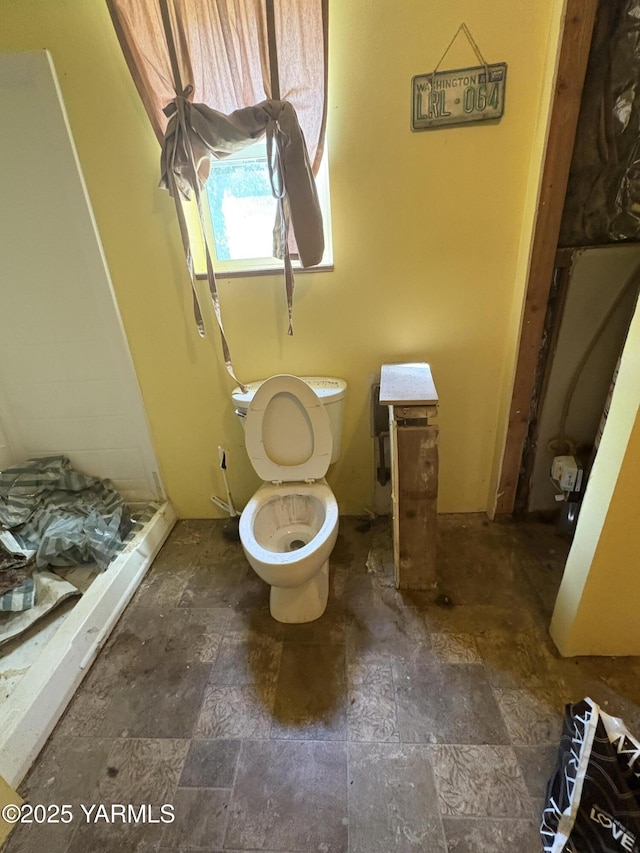 full bathroom with toilet and stone finish flooring