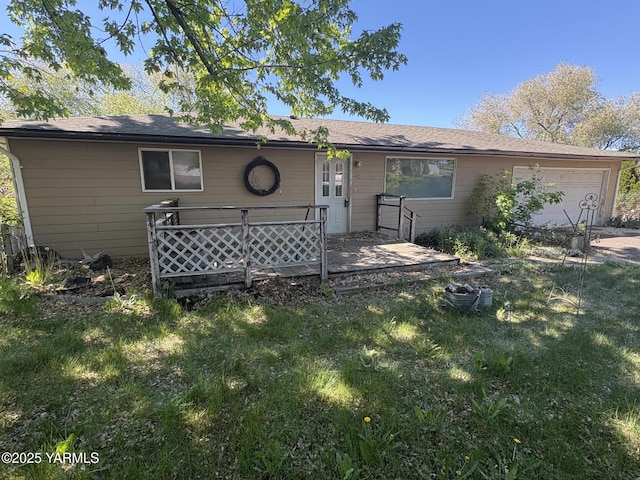 rear view of house featuring a yard and an attached garage