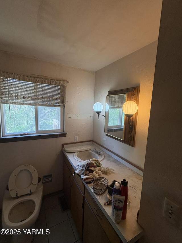 bathroom with vanity, a healthy amount of sunlight, and tile patterned flooring