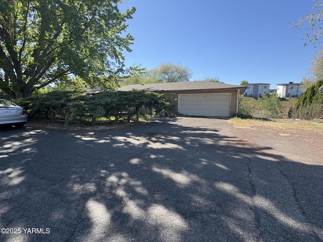 view of front of property with dirt driveway and a garage