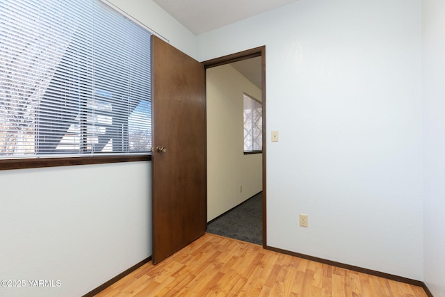 unfurnished room featuring light wood-type flooring and baseboards