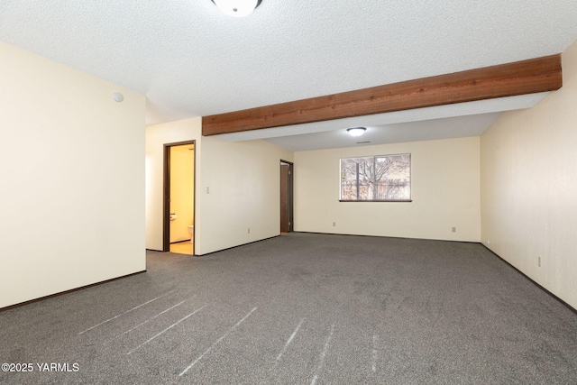 unfurnished room featuring a textured ceiling, beamed ceiling, and carpet flooring