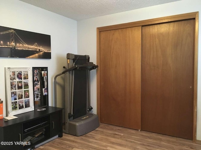 interior space featuring light wood-type flooring and a textured ceiling