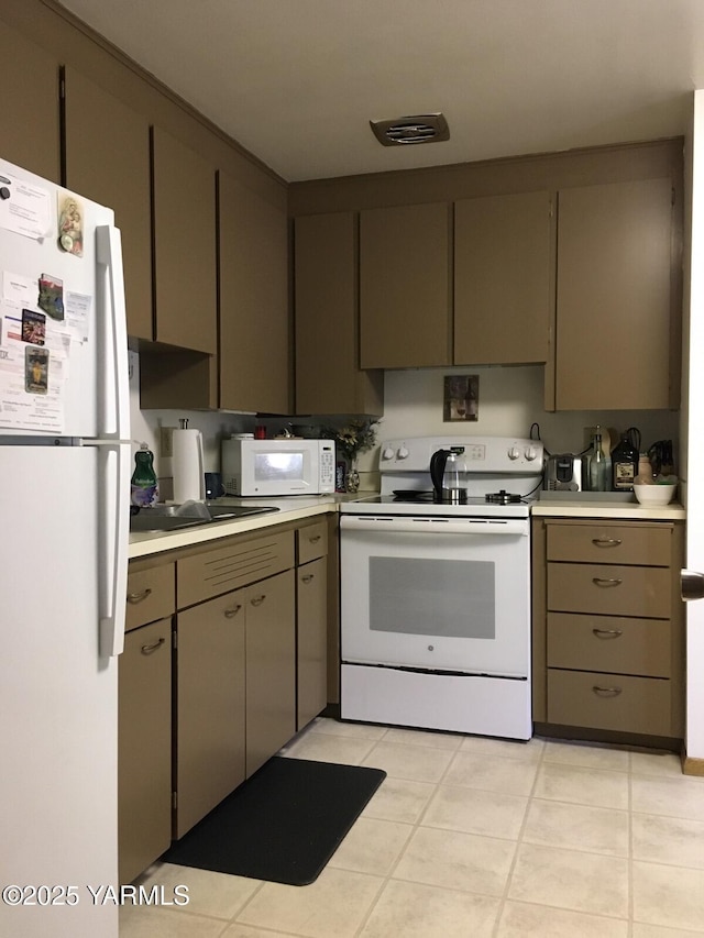 kitchen with white appliances, light countertops, and light tile patterned flooring