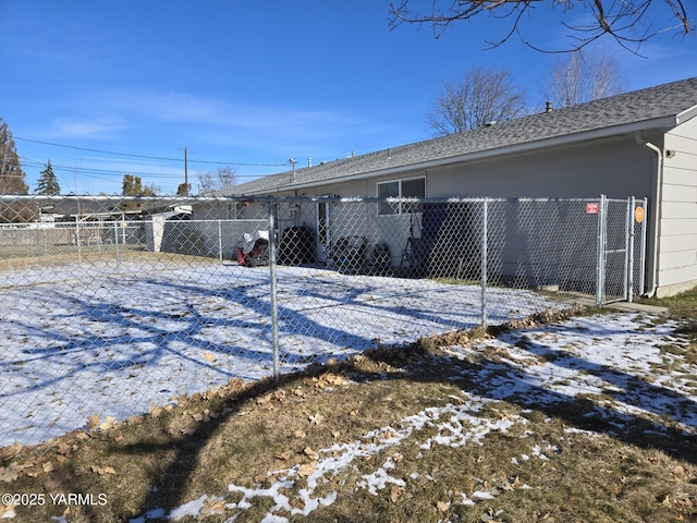 exterior space with a shingled roof and fence