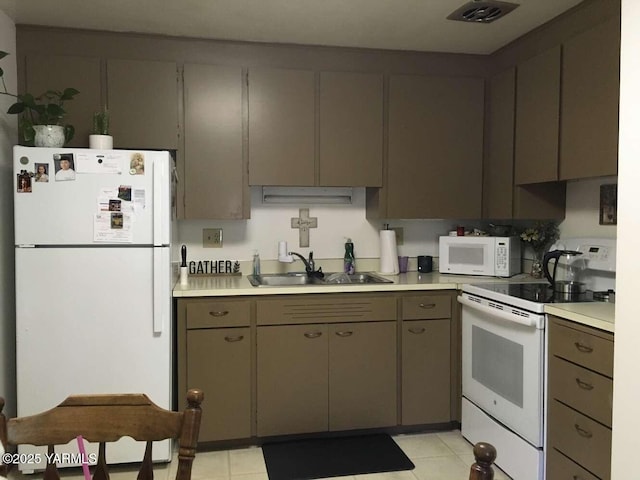 kitchen featuring white appliances, visible vents, light countertops, and a sink