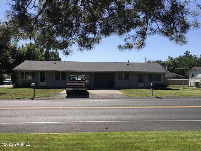 ranch-style house with fence and a front lawn