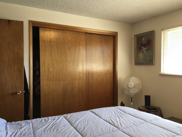 bedroom with a textured ceiling and a closet