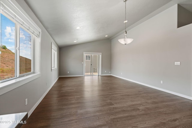 empty room with lofted ceiling, plenty of natural light, dark wood-style floors, recessed lighting, and baseboards