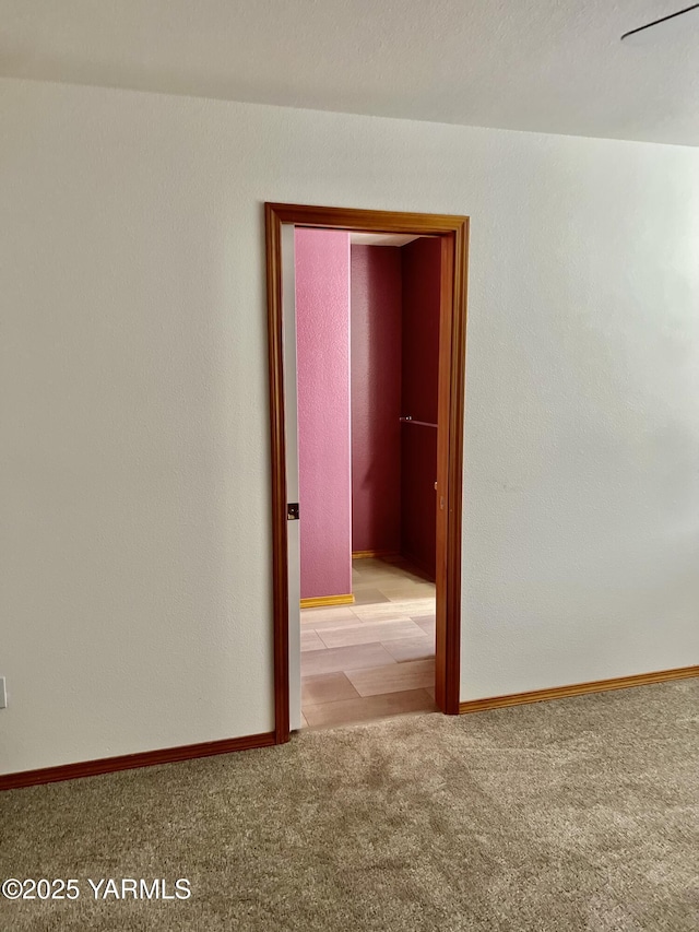 empty room with baseboards and light colored carpet