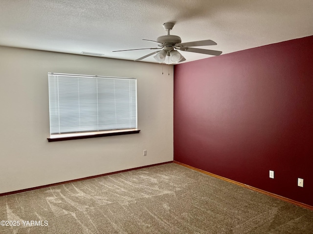 carpeted spare room with a textured ceiling, ceiling fan, visible vents, and baseboards