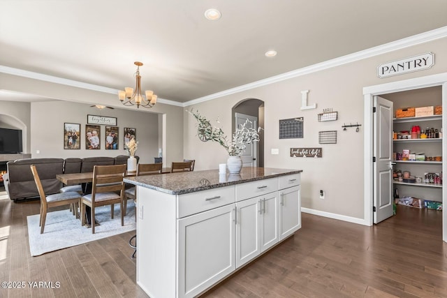 1589 Valhalla Loop, Selah, WA 98942 - kitchen featuring arched walkways, white cabinetry, dark wood finished floors, a kitchen island, and a chandelier