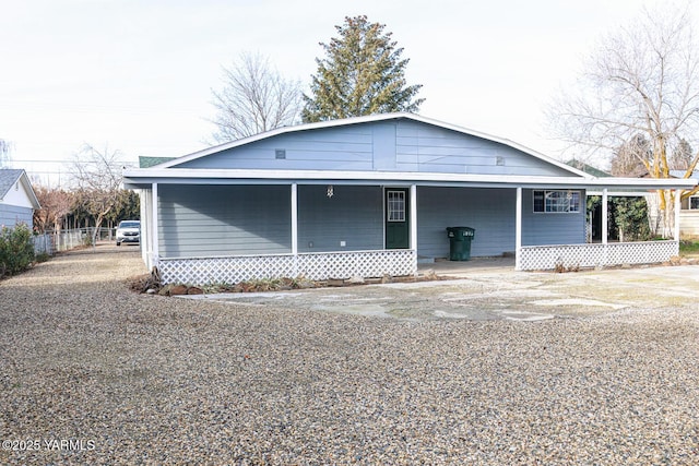 view of front of home featuring a porch, concrete driveway, and fence