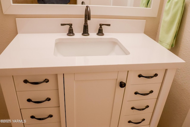 details with a textured wall and vanity