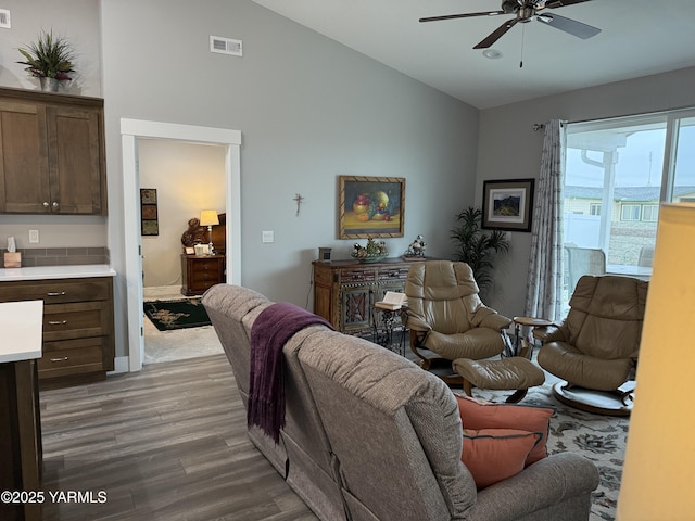 living room with lofted ceiling, visible vents, ceiling fan, and wood finished floors