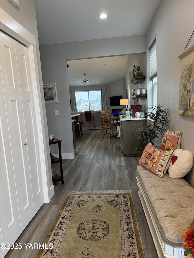 hall featuring recessed lighting, dark wood finished floors, and baseboards