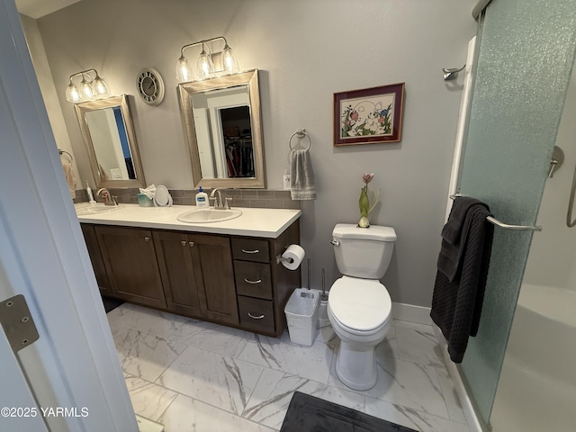 full bathroom with baseboards, toilet, marble finish floor, a walk in closet, and vanity