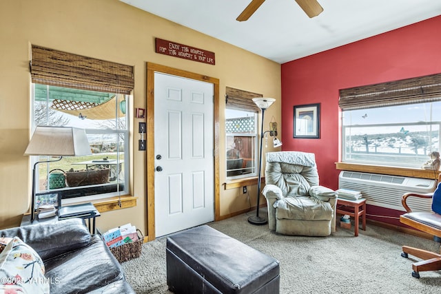 interior space with a ceiling fan, an AC wall unit, carpet, and baseboards