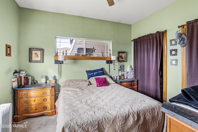 bedroom featuring radiator heating unit, a ceiling fan, and carpet floors