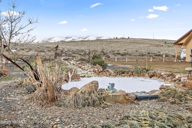 view of yard with a mountain view and fence