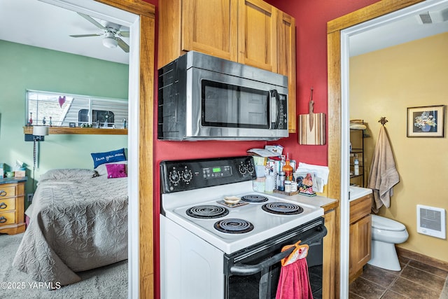 kitchen featuring visible vents, white electric stove, ceiling fan, stainless steel microwave, and dark tile patterned floors