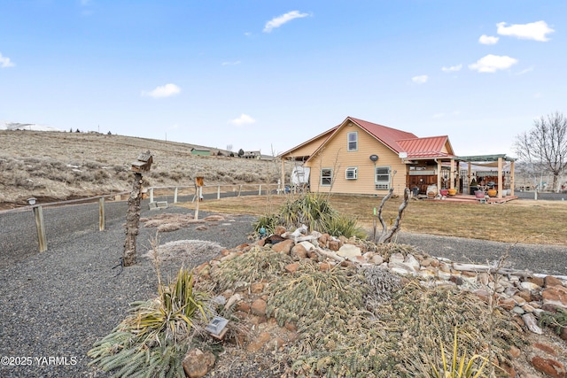 view of home's exterior with metal roof and fence