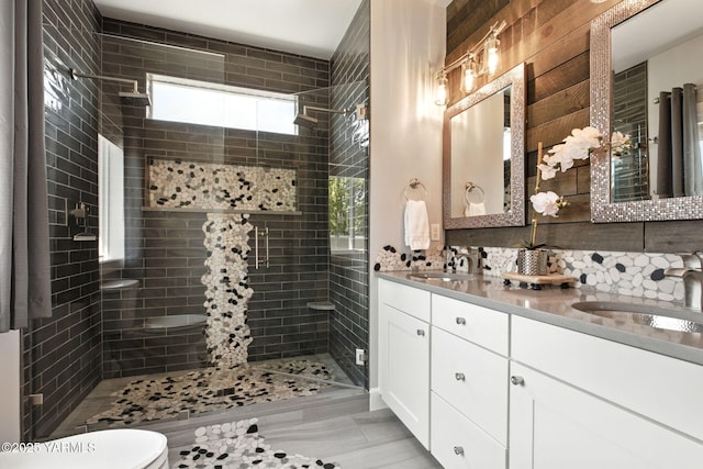 bathroom with a sink, a shower stall, toilet, and double vanity