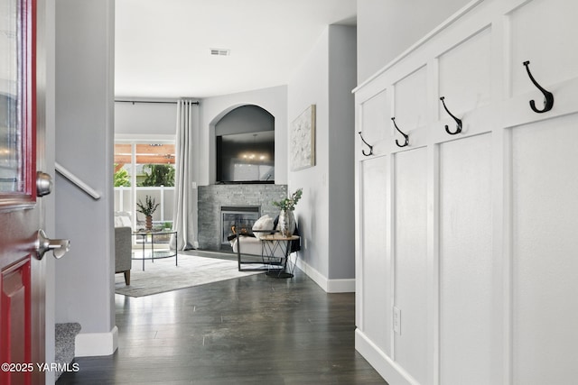 interior space featuring baseboards, visible vents, wood finished floors, and a fireplace