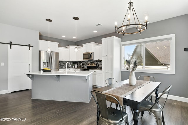 dining area with a barn door, baseboards, a notable chandelier, recessed lighting, and dark wood-type flooring
