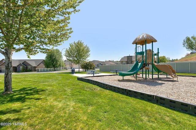community jungle gym with a yard, fence, and a residential view