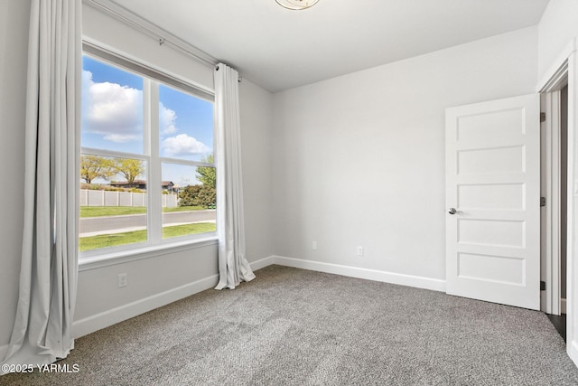 carpeted spare room with baseboards and a healthy amount of sunlight