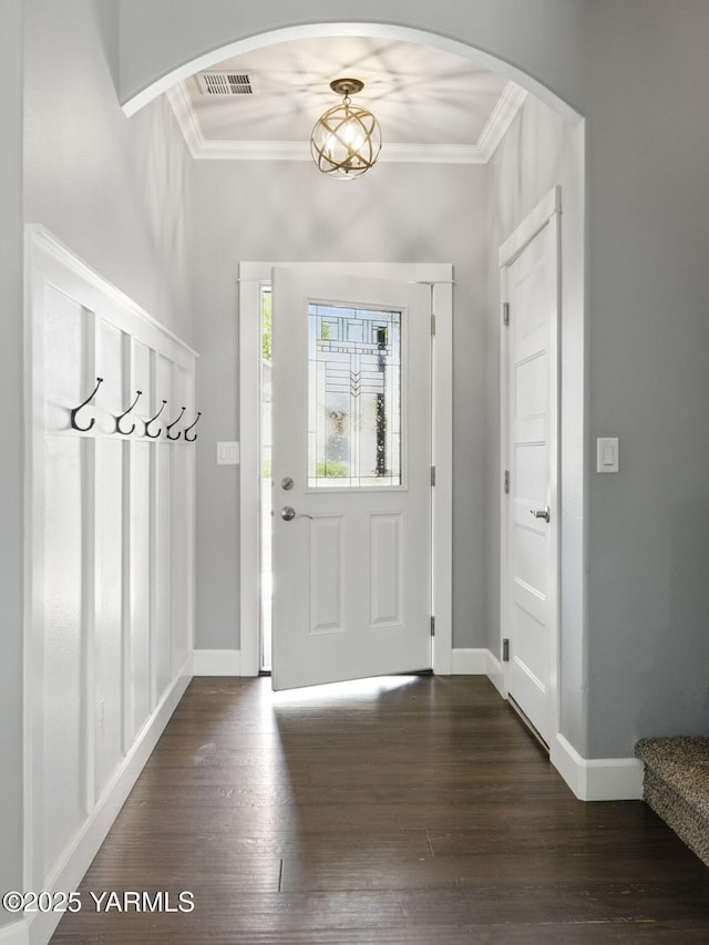 foyer with baseboards, dark wood-style floors, ornamental molding, and visible vents
