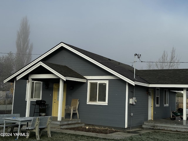 back of house with a shingled roof