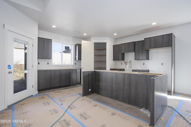 kitchen featuring recessed lighting, modern cabinets, dark brown cabinets, and a center island