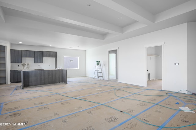 unfurnished living room featuring beam ceiling and recessed lighting