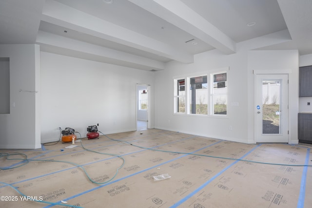 interior space with beamed ceiling and baseboards