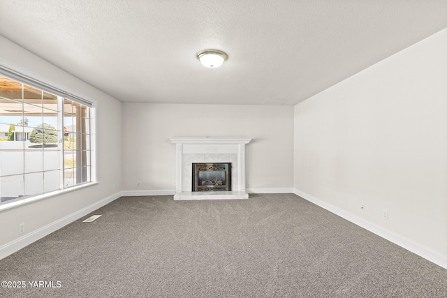 5804 W Walnut St, Yakima, WA 98908 - unfurnished living room featuring carpet, a tiled fireplace, and a textured ceiling