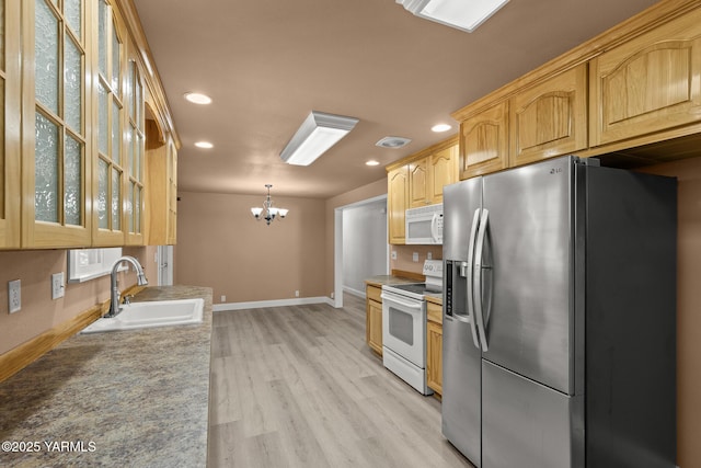 5804 W Walnut St, Yakima, WA 98908 - kitchen with white appliances, recessed lighting, glass insert cabinets, a chandelier, and light wood finished floors