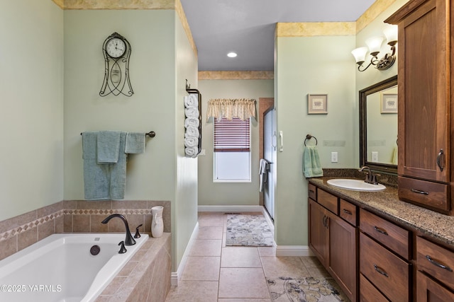 bathroom with a garden tub, tile patterned flooring, baseboards, and vanity