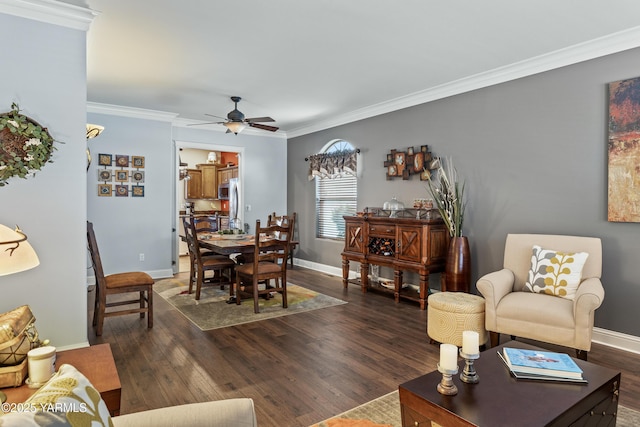 living room featuring dark wood-style floors, ornamental molding, a ceiling fan, and baseboards