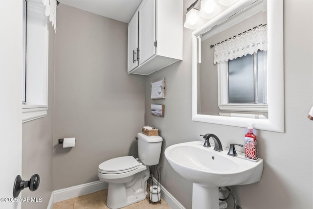 bathroom featuring tile patterned flooring, toilet, and baseboards