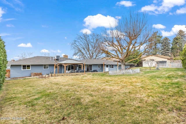 back of property featuring a patio area, a chimney, a yard, and fence