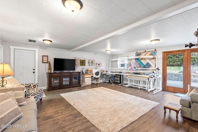 living room featuring visible vents, baseboards, and wood finished floors