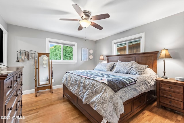 bedroom featuring light wood-type flooring, baseboards, and a ceiling fan