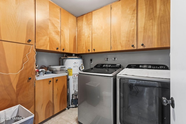 clothes washing area featuring gas water heater, cabinet space, and washing machine and clothes dryer