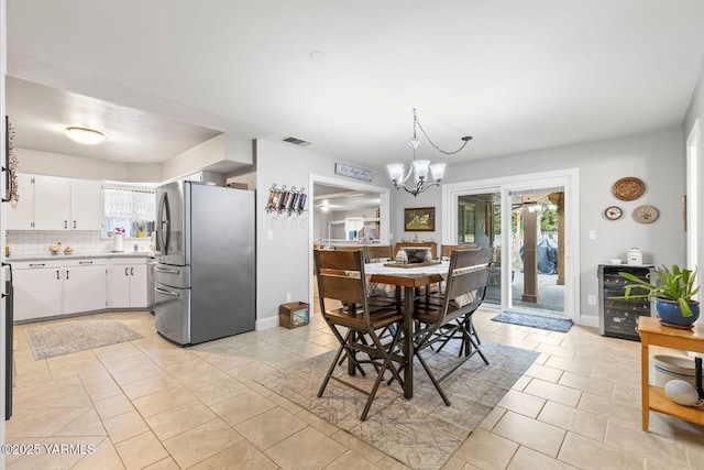 dining room featuring a notable chandelier, baseboards, visible vents, and light tile patterned floors