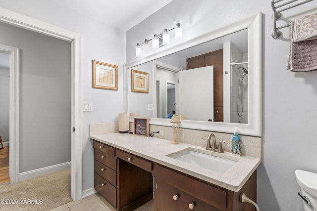 bathroom with vanity, baseboards, walk in shower, tile patterned floors, and toilet