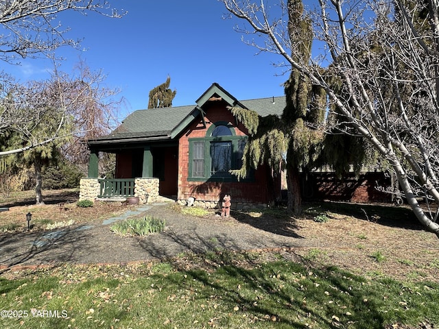 view of front of home featuring roof with shingles and covered porch