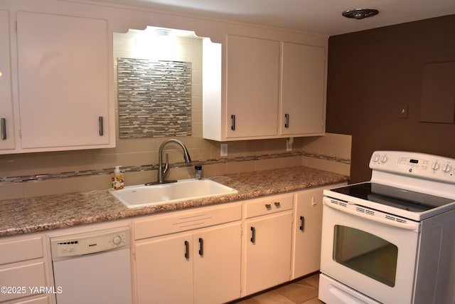 kitchen featuring white appliances, decorative backsplash, a sink, and light countertops